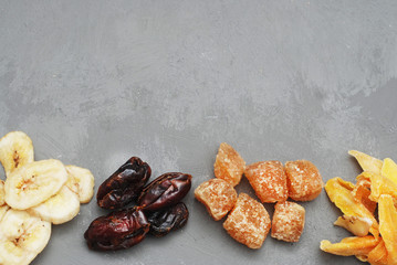 Assortment of Dried Fruits: Banana, Ginger, Mango over Gray Background with copy space.