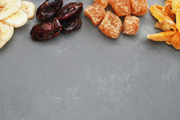 Assortment of Dried Fruits: Banana, Ginger, Mango over Gray Background with copy space.