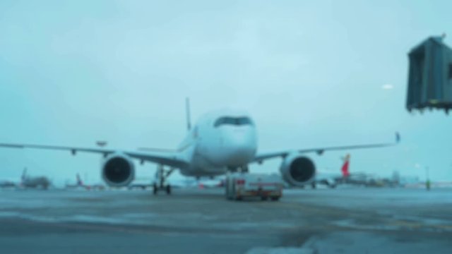 Tow Tractor towing a passenger plane on the runway of the airfield. Defocused Shot