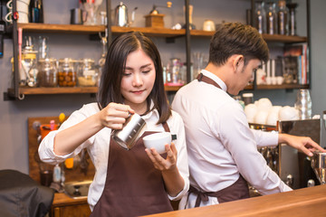 Asian female barista making coffee in coffee shop counter.  Barista female working at cafe. Woman working with small business owner or sme concept.