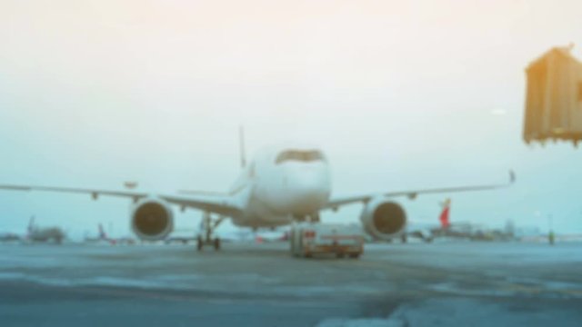 Tow Tractor towing a passenger plane on the runway of the airfield. Defocused Shot