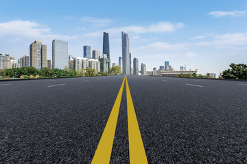 Fototapeta premium The empty asphalt road is built along modern commercial buildings in China's cities.