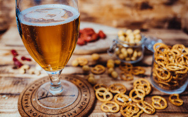 Lager beer mug and snacks on wooden table. Nuts, chips. Top view with copyspace