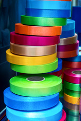 A stack of rolls of multi-colored ribbon