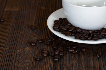 Roasted coffee beans with white cup on white wood table. coffee background with copy space...Roasted coffee beans with white cup on dark brown wood table. coffee background with copy space