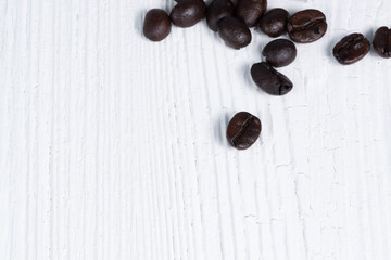 Roasted coffee beans on white wood table. coffee background with copy space.