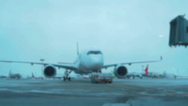 Tow Tractor towing a passenger plane on the runway of the airfield. Defocused Shot