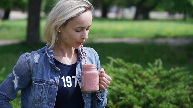 Girl in denim clothes holding smoothie