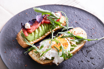 Toast with veggies,avocado, arugula, basil, tomato, mozzarella cheese  and sunny side up egg