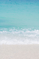 Fototapeta na wymiar Soft wave of blue ocean on sandy beach. Background.