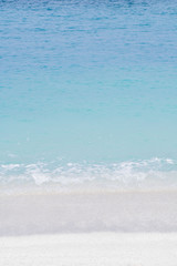 Soft wave of blue ocean on sandy beach. Background.