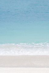 Fototapeta na wymiar Soft wave of blue ocean on sandy beach. Background.