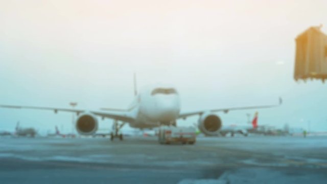 Tow Tractor towing a passenger plane on the runway of the airfield. Defocused Shot