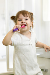 Dental hygiene. Smiling child girl brushing her teeth.