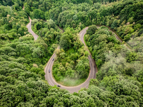 Aerial view of a curved road in the forest shot with a drone