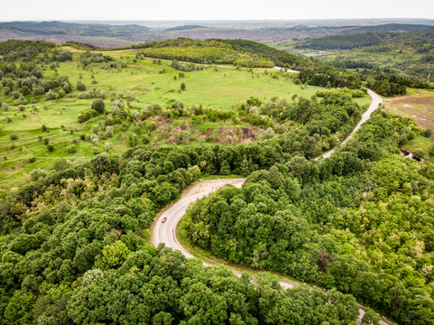 Winding road trough the forest on a hill top