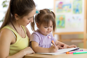 Fototapeta premium Mother and child of two years drawing and coloring at home