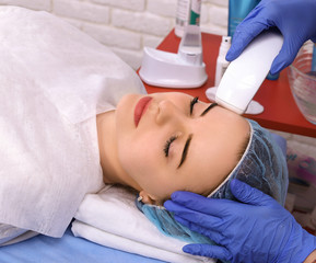 Woman doing cosmetic procedures in spa clinic.