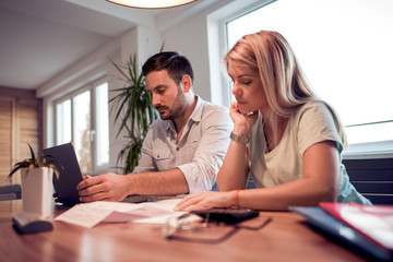 Fototapeta premium Young couple calculating bills at home