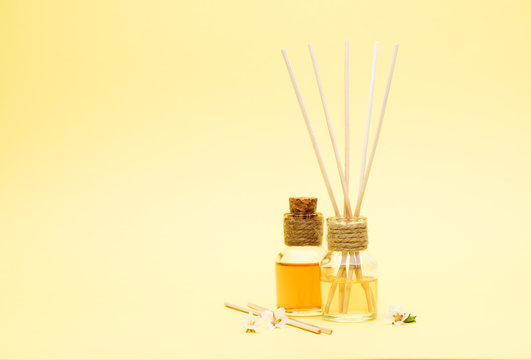 Fragrant Oil Diffusers with Reed Sticks on a yellow background