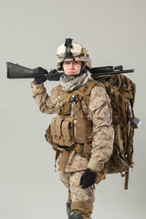 Soldier in camouflage holding rifle