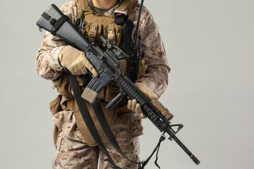 Soldier in camouflage holding rifle