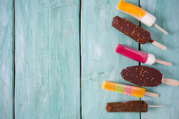various ice cream popsicles on wooden surface