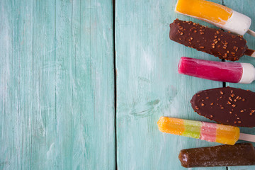 various ice cream popsicles on wooden surface