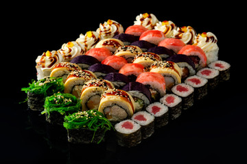 Fresh Sushi rolls set served on black background. Japanese seafood sushi