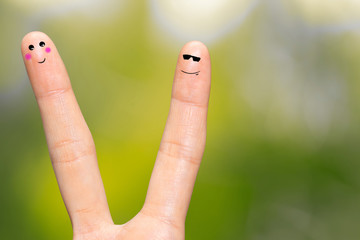 Human hand fingers with funny painted emoticons. People relationships concept