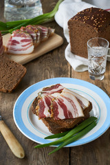 Piece of rye bread with salted lard on a plate