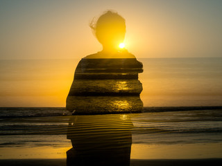 Double exposure portrait of a young girl by the sea at sunset