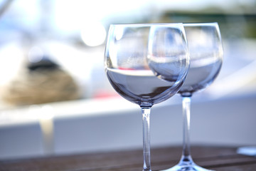 Pair of wineglasses against the yacht