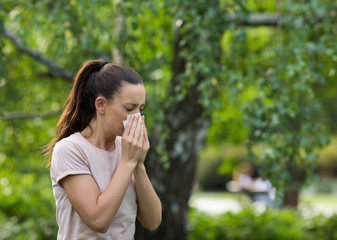 Girl blowing nose because of pollen allergy