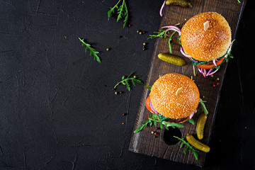 Big sandwich - hamburger burger with beef,  tomato, basil cheese and arugula. Top view. Flat lay © timolina