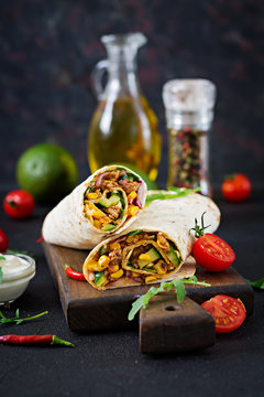 Burritos wraps with beef and vegetables on  black background. Beef burrito, mexican food.
