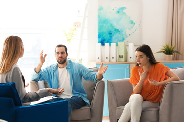 Family psychologist working with young couple in office