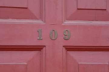 House number 109 sign on door painted red