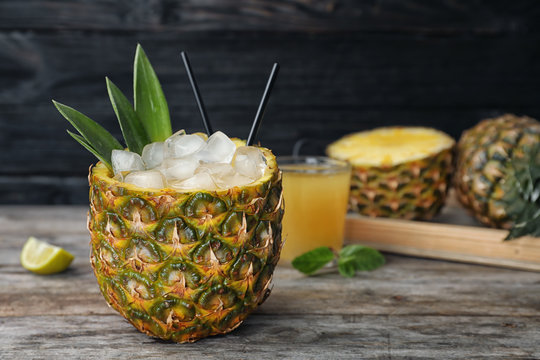 Pineapple with juice and ice cubes on table