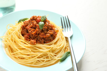 Plate with delicious pasta bolognese on table