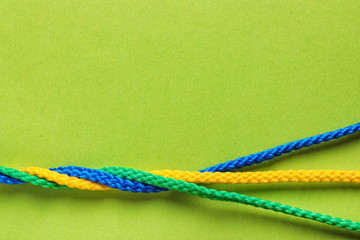 Twisted ropes on color background, top view. Unity concept