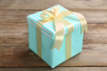 Elegant gift box with bow on wooden background