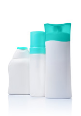 Blank white mockup dispenser and figured bottles of cosmetic products with turquoise lids