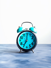 Blue alarm clock on abstract background. Time concept. Waking up in the morning