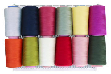 Sewing threads on spool in the white metal grid.