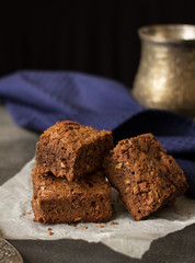 Appetizing pieces of chocolate cake with nuts on napkin