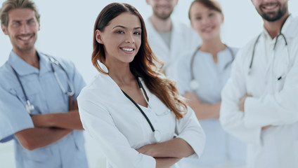 Attractive female doctor with medical stethoscope in front of medical group