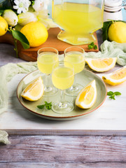 Home made limoncello served in stemmed glasses. Summer still life