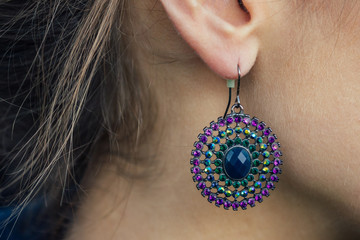 female earrings on the female ear in the form of stones. Handmade