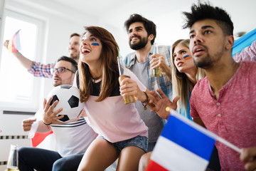 Obraz premium Soccer fans emotionally watching game in the living room.